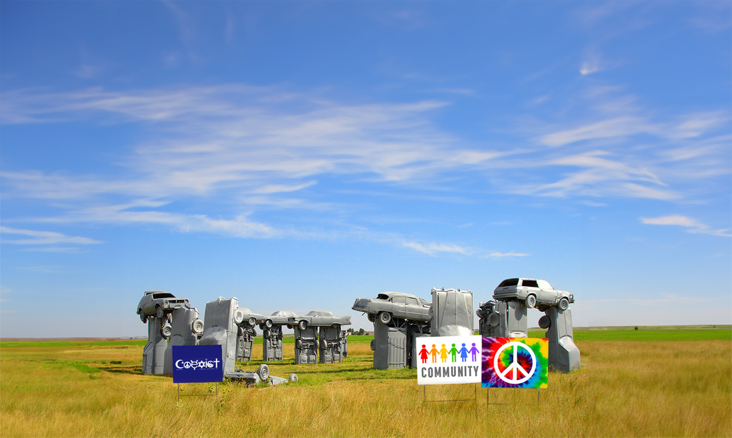 Carhenge monument in Nebraska with yard signs celebrating "Coexist," "Community" and "Peace"